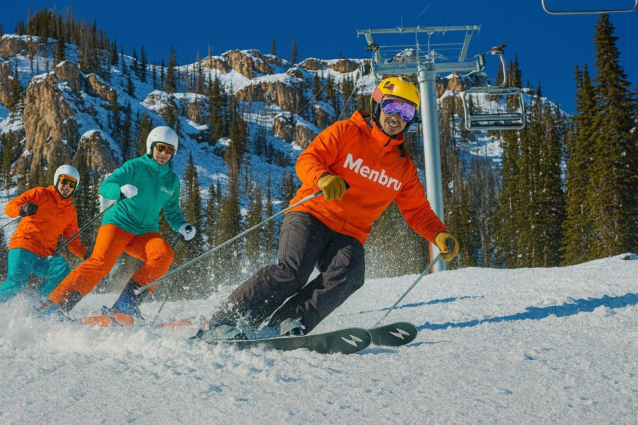 A stunning autumn landscape in Jackson Hole, Wyoming, featuring the Teton Mountains reflected in a calm river surrounded by colorful trees.